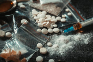 Hard drugs on dark table. Drug syringe and cooked heroin